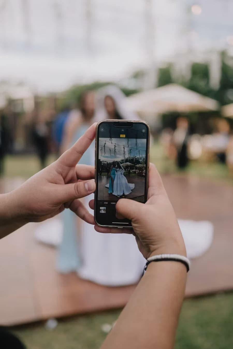 Gast fotografiert mit dem Handy das Brautpaar auf der Tanzfläche
