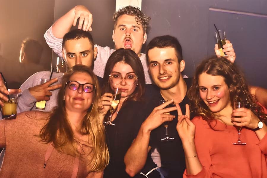 Gruppe feiert abends mit Gläsern in der Hand